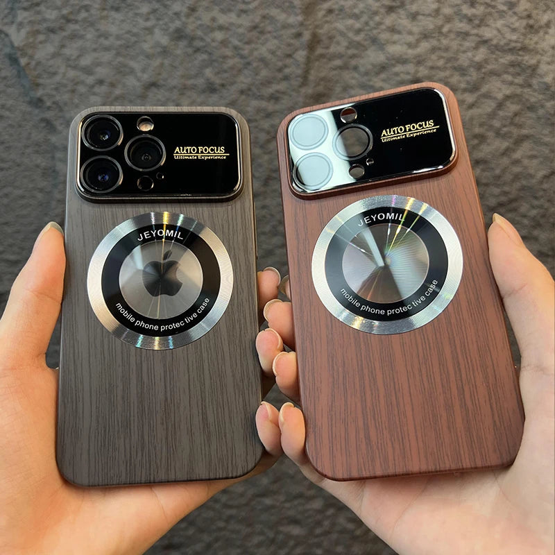 Two wooden iphone cases with metallic accents held by a person against a gray background