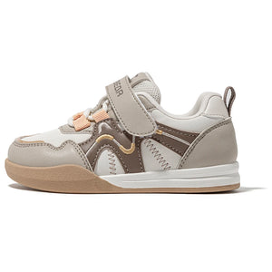A children's low-top sneaker in light gray and taupe with peach-colored hook-and-loop straps and a beige outsole, shown from the side on a white background.