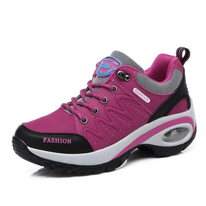 Pink sneaker with black and white accents on a white background