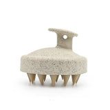 Beige scalp massager with textured surface on a white background