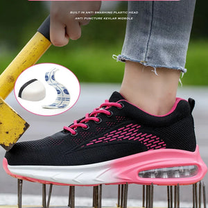 A black Women's Safety Work Shoes with bright pink laces, pink trim, and a white midsole with a pink air cushioning unit, shown being worn outdoors with a hand holding a spiked yellow pole. A circular inset shows the shoe's protective toe cap detail.