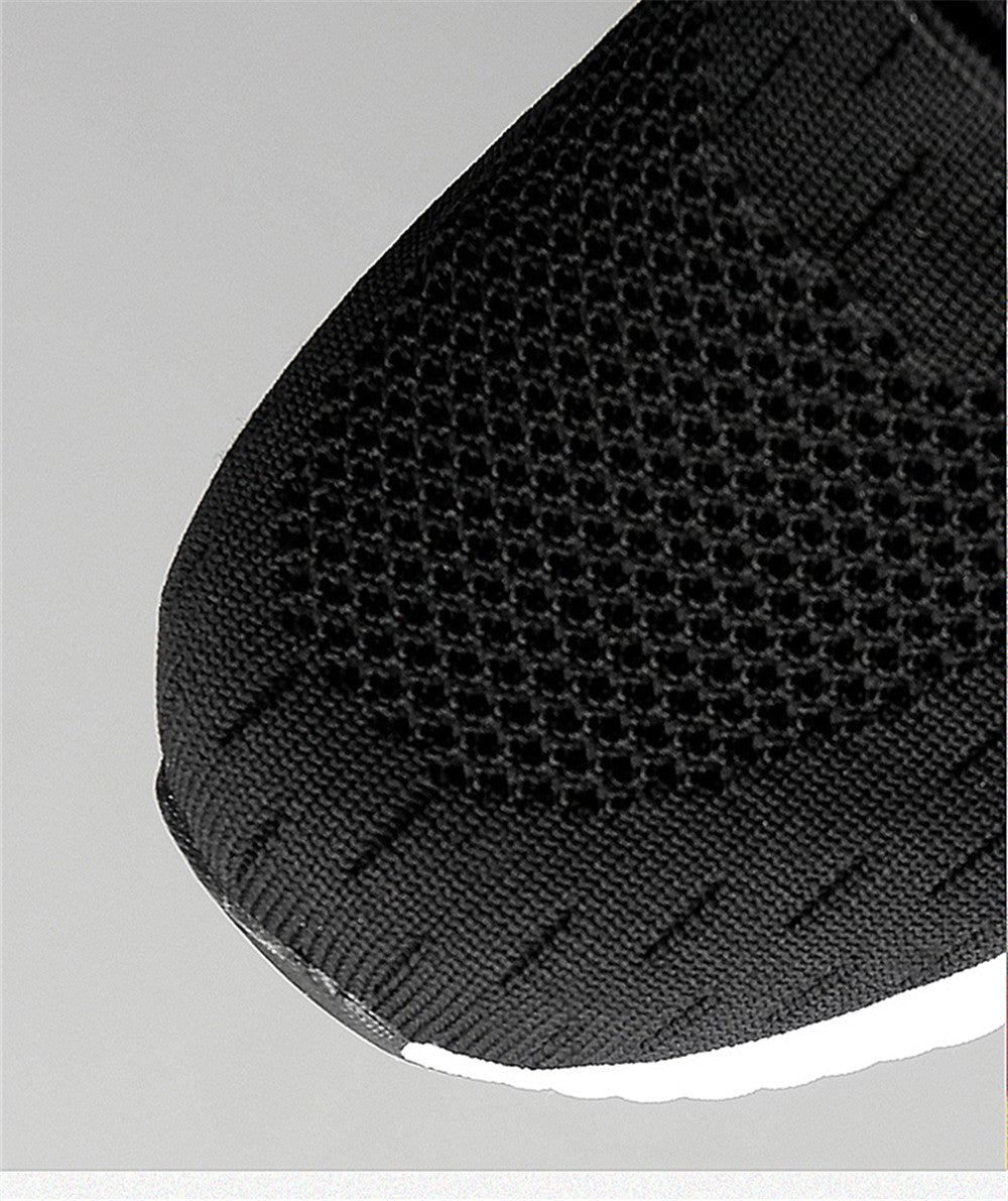 Close-up of a black shoe sole with textured pattern on a light gray background