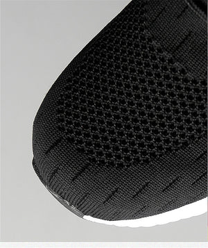 Close-up of a black shoe sole with textured pattern on a light gray background