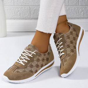Beige patterned sneakers with white laces worn indoors on a light background