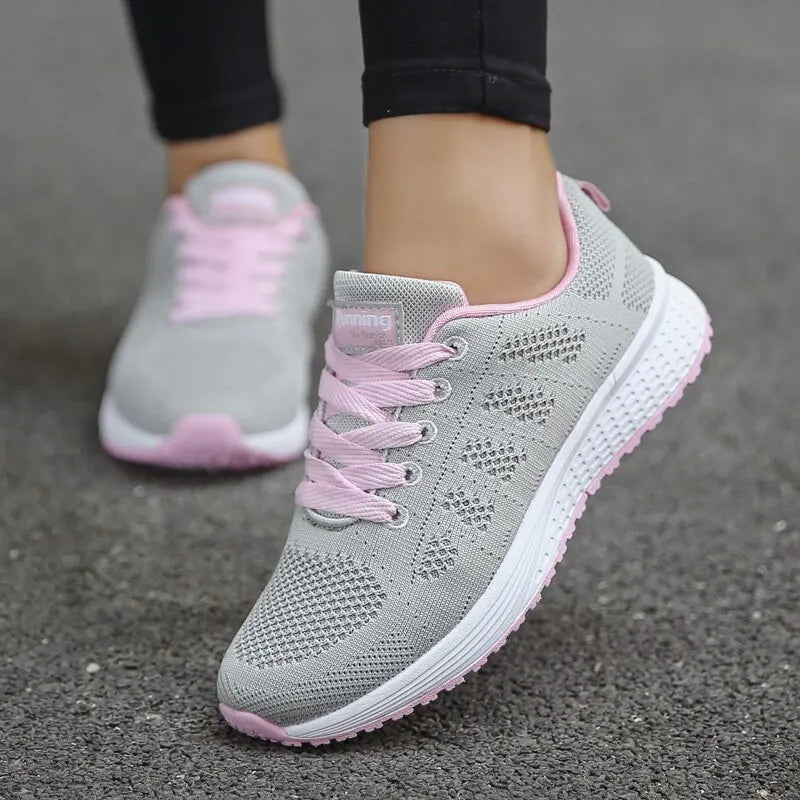 Gray and pink sneakers on a gray pavement background