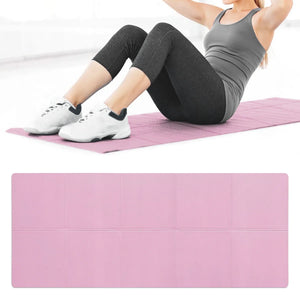Person exercising on a pink yoga mat with a pink block in the foreground