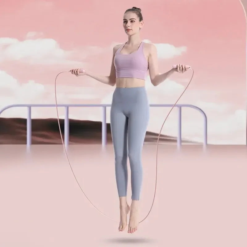 Woman skipping Smart jump rope against a pink background with clouds