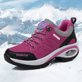 A pink and black winter hiking shoe with a white midsole, shown in a snowy mountain landscape. The shoe features pink laces, a pink and black toe cap, and the word 'FASHION' printed on the side and tongue.