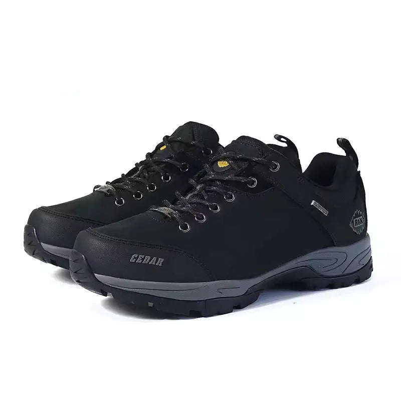 A pair of black outdoor hiking shoes with gray soles and small yellow accents, shown on a white background.