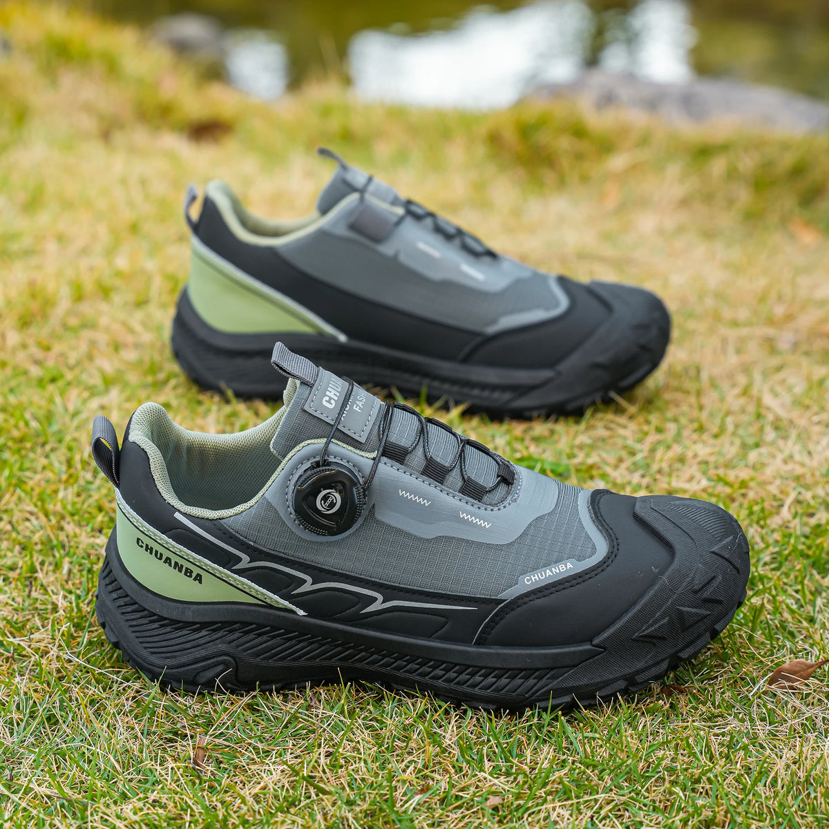 Pair of gray and black shoes on grass with a blurred natural background