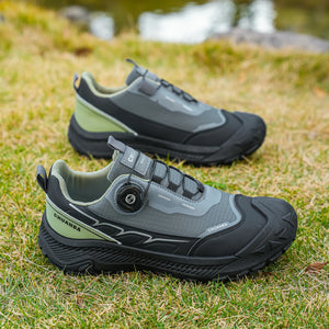 Pair of gray and black shoes on grass with a blurred natural background