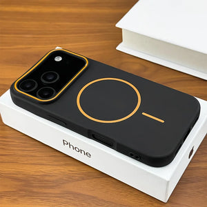 Black phone case with gold accents on a white box against a wooden background