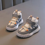 A pair of children's low-top sneakers in white and gray with small orange accents, displayed on a gray textured surface.