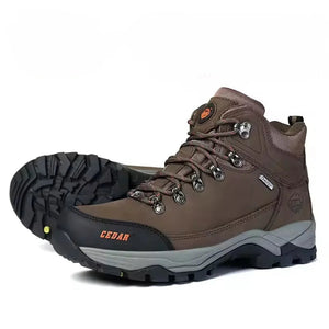 A pair of brown mid-cut waterproof hiking boots with black and gray soles, shown on a white background.