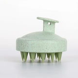 Green scalp massager on a white background