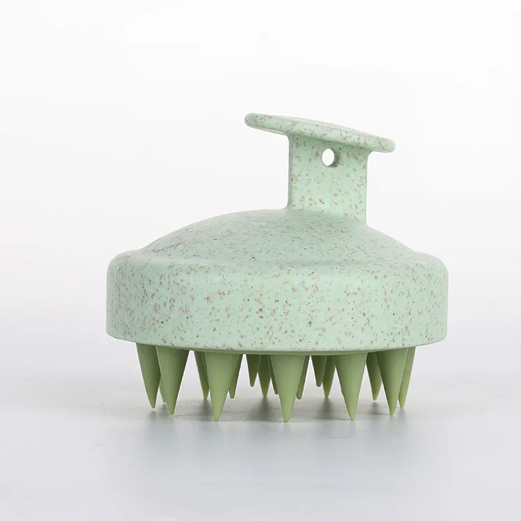 Green scalp massager on a white background