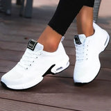 White sneakers with black accents on a wooden floor