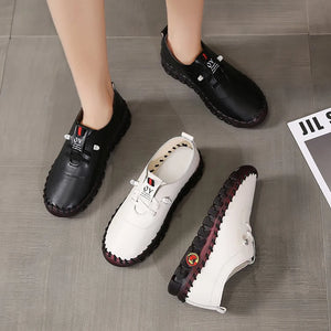 Black and white lace-up split leather casual flats with round toes and rubber outsoles on a gray floor with 'JIL' branding.