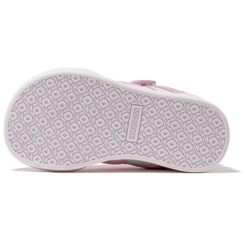 The outsole of a children's shoe in light pink and white, featuring a textured geometric tread pattern and the brand name 'UGEBONI' embossed on the center.