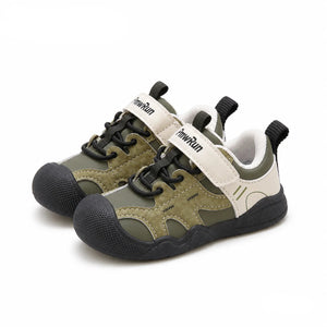 A pair of toddler safety shoes in green and beige with black soles, shown on a white background with the PmwRun brand logo in the top left and the word 'Green' in the bottom right.