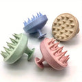 Four textured scalp massage brush in pastel colors on a white background