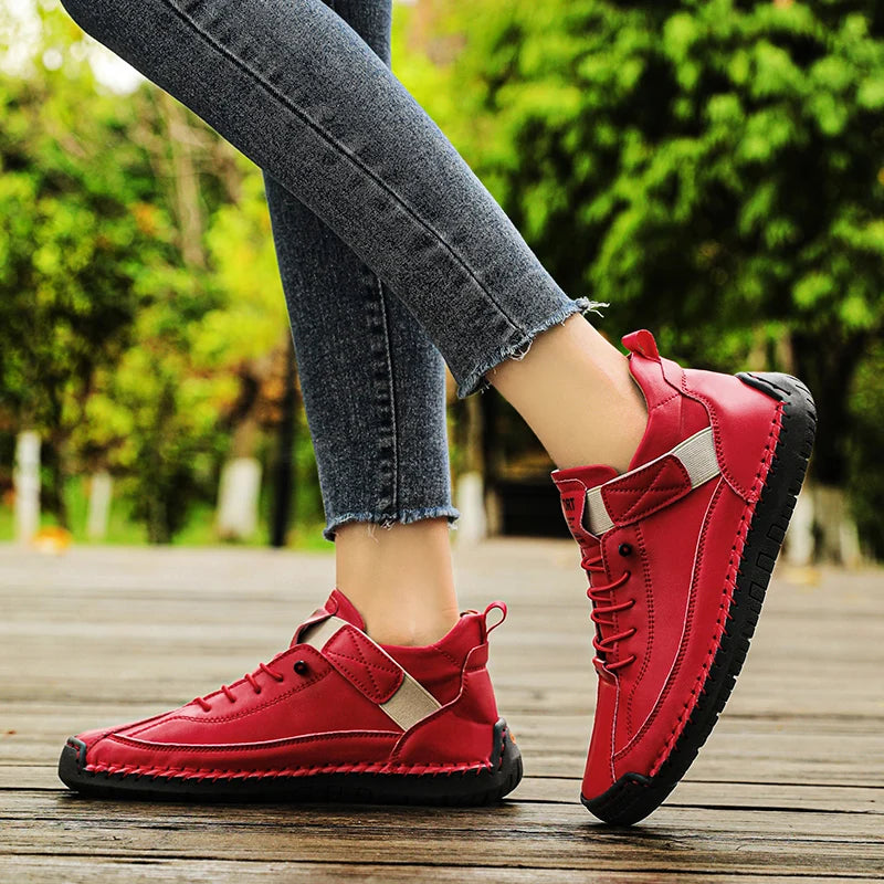 Red Slip-On Shoes worn with gray jeans on a wooden floor with greenery in the background