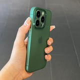 Hand holding a green Ultra thin matte translucent TPU iPhone case with a dark background