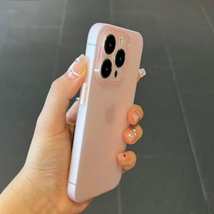 Hand holding a pink Ultra thin matte translucent TPU iPhone case with a clear case on a dark surface
