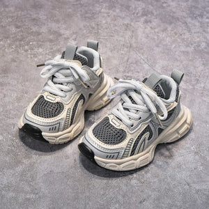 Pair of gray sneakers on a concrete surface