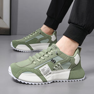 Green and white sneakers worn by a person on a gray floor.