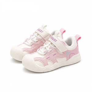 A pair of children's sneakers in white and light pink, featuring hook-and-loop straps, laces, and a textured rubber sole, shown on a white background with the PmwRun logo in the top left corner.