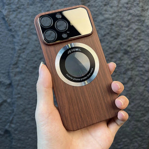 Hand holding a wooden iphone case with a metallic ring on a dark textured background