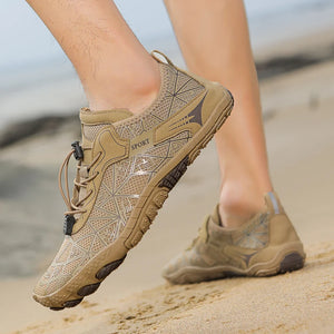 Beige hiking shoes on a beach with blurred background