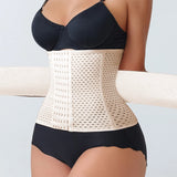 Person wearing a beige waist trainer with a black bra and underwear set on a light gray background
